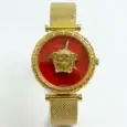 Gold Medusa watch with red dial and mesh strap, luxury fashion accessory.