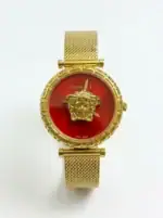 Gold Medusa watch with red dial and mesh strap, luxury fashion accessory.