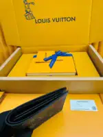 Black Louis Vuitton wallet with monogram pattern and zipper closure.