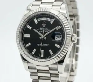 Rolex Day-Date watch with black dial, baguette hour markers, and stainless steel bracelet.