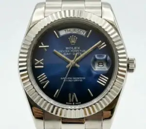 Rolex Day-Date watch with blue dial, Roman numerals, and stainless steel bracelet.