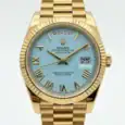 Rolex Day-Date watch with turquoise dial and gold bracelet, day and date display.