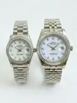 Pair of Rolex Datejust watches with silver bands and white dials, one with diamond hour markers.