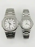 Pair of Patek Philippe Nautilus watches in silver with white dials.