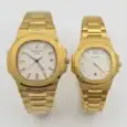 Gold Patek Philippe Nautilus couple watches with white dials and gold bracelets.