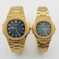 Gold Patek Philippe Nautilus couple watches with blue dials and gold bracelets.