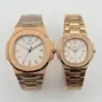 Pair of rose gold Patek Philippe Nautilus watches with white dials and bracelet straps.