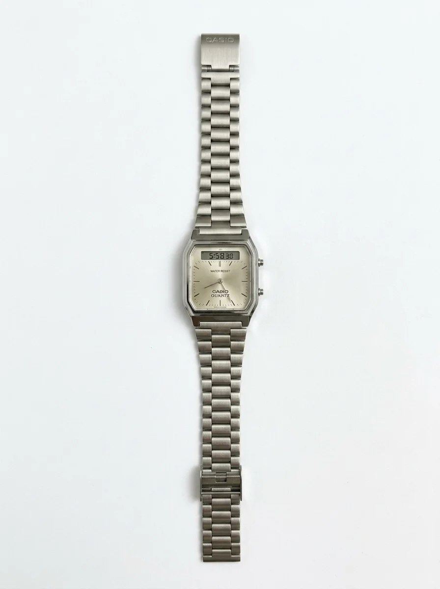Isolate_metal_wristwatch_on_white_20261009010353 ساعة كاسيو كوارتز بمينا فضي بلون الشمبانيا وشاشة مزدوجة ومقاومة للماء - الصورة 1